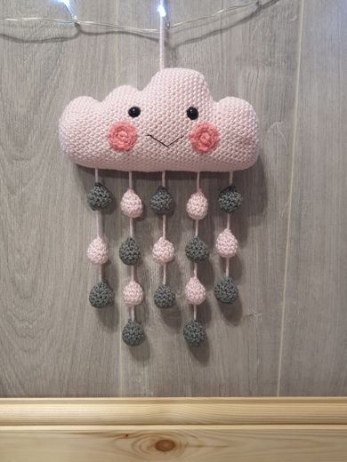 A hand-crocheted pink cloud mobile with hanging raindrops