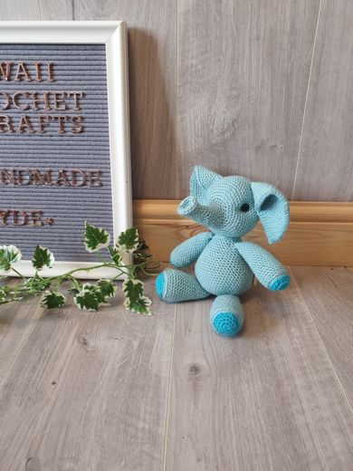 A hand-crocheted amigurumi elephant in soft blue