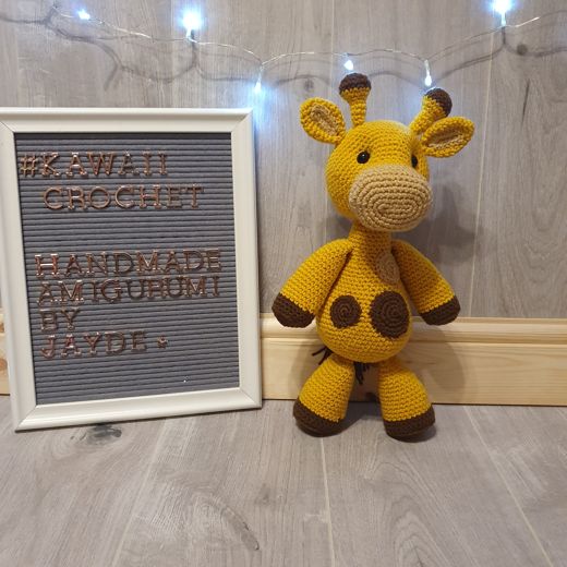 A hand-crocheted amigurumi giraffe with brown spots